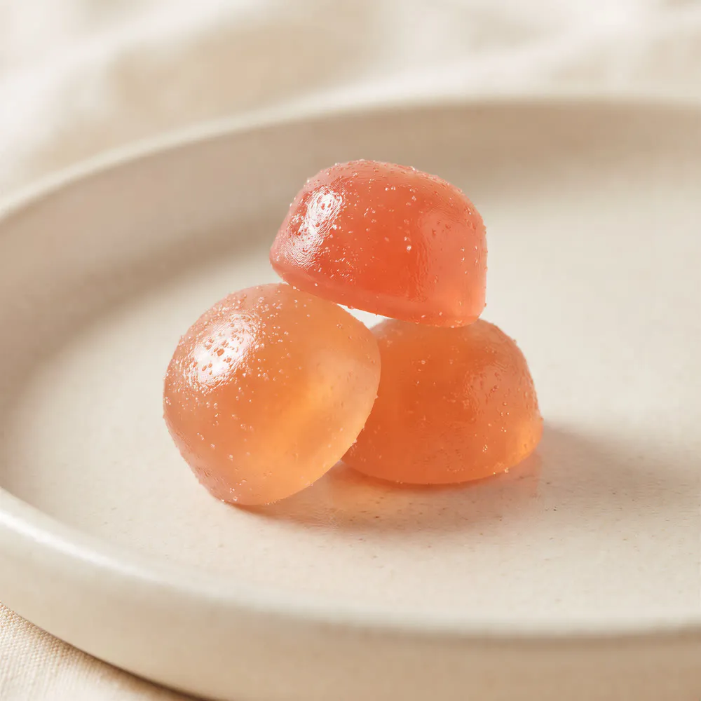 Three creatine gummies on a ceramic plate
